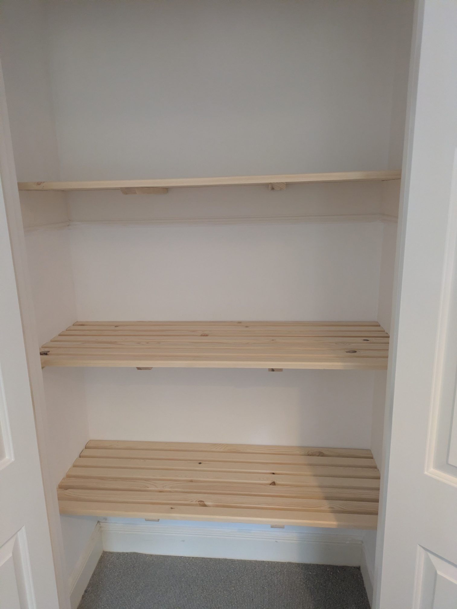 Pine slatted shelves fitted inside an airing cupboard