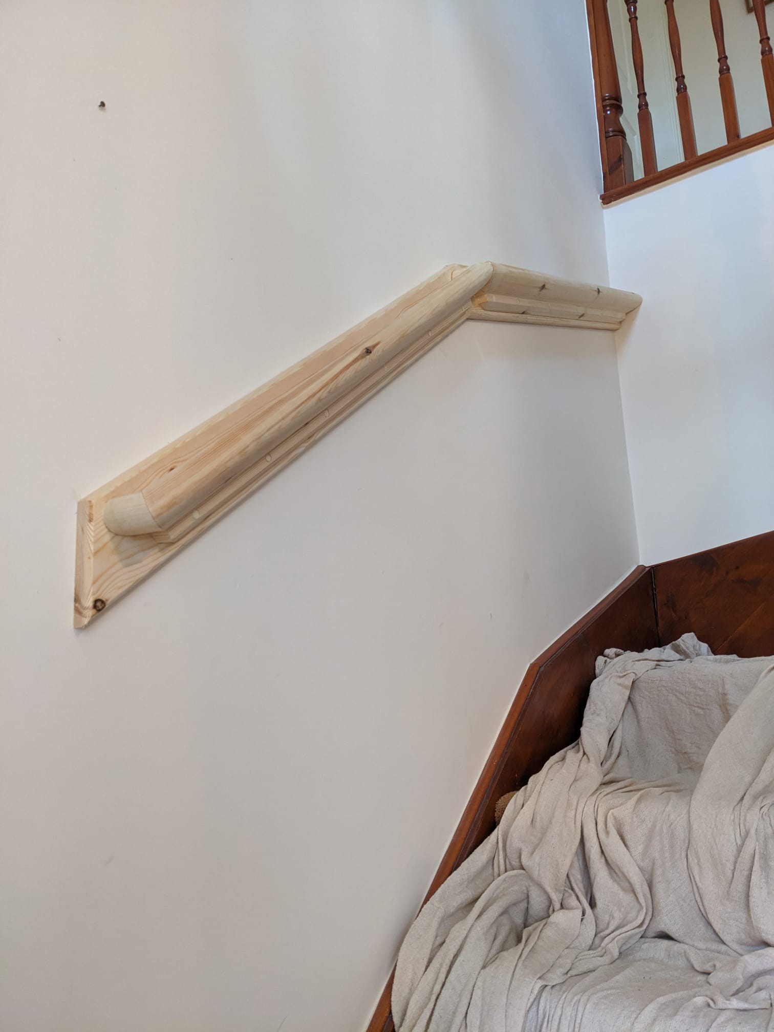 New pine stair handrail fitted to a wall