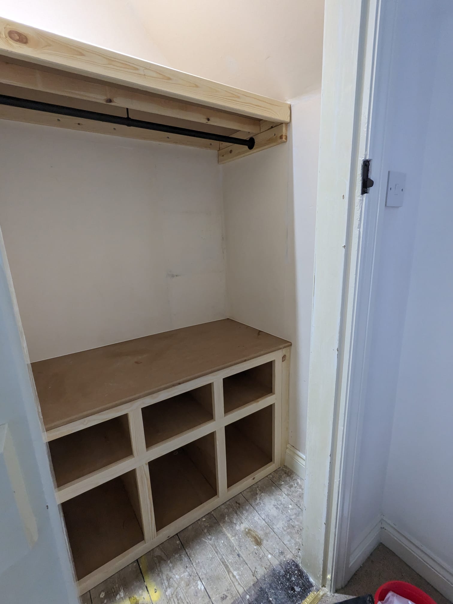 Built-in under-eaves wardrobe with hanging rail, shelf and cubby bench storage